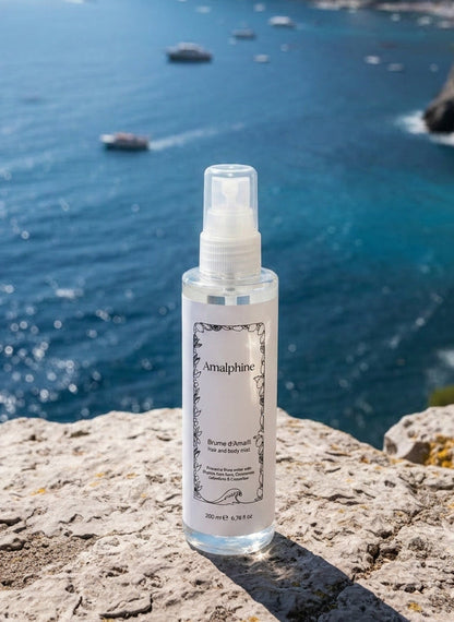 Body mist bottle with scenic background of Amalfi Coast and cliffside village