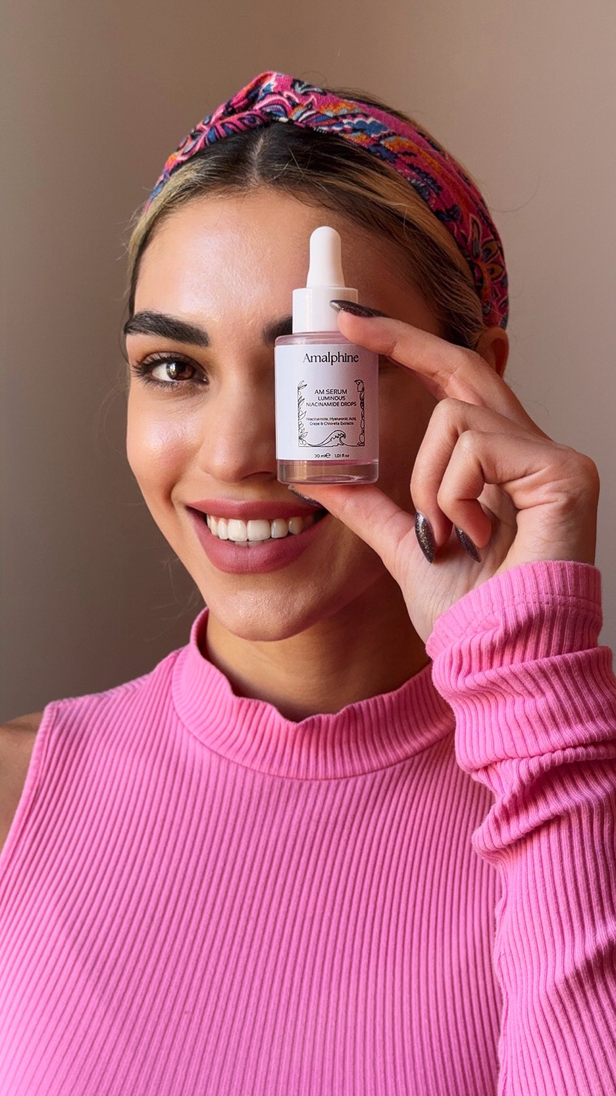 Woman holding an Amalphine niacinamide serum bottle 